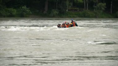 İnsanlar bir nehirde rafting