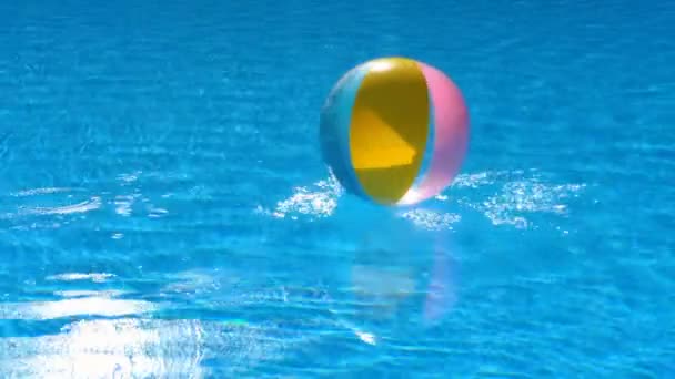 Pelota de playa flotando en la piscina — Vídeo de stock