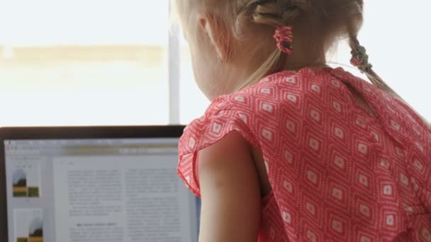 Petite fille blonde utilisant un ordinateur portable — Video
