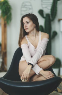 Genç tek güzel kızla sandalyede oturan ve uzağa bakarak şehvetli dalgın yüz. İnanılmaz genç ruh dikey, mavi gözlü kadın