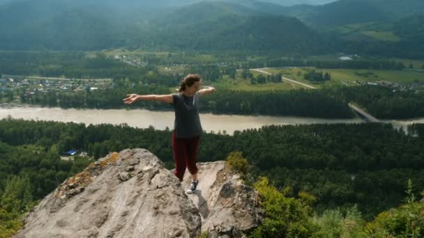 Woman with arms raised on top of mountain — Stock Video