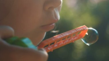 Küçük kız sabun köpüğü üflüyor