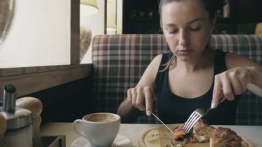 Kahvaltı. Genç kadın cafede yiyor