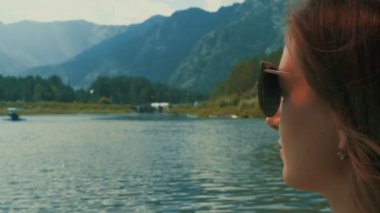 Dağ ve göl ile pitoresk manzara karşı güneş gözlüklü genç kafkas kadın portresi portre