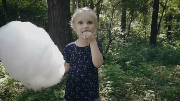 Очаровательная девочка ест сахарную вату — стоковое видео