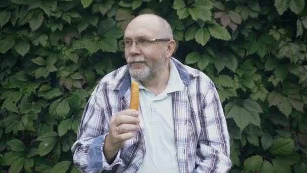 Starszy człowiek jeść marchewki — Wideo stockowe