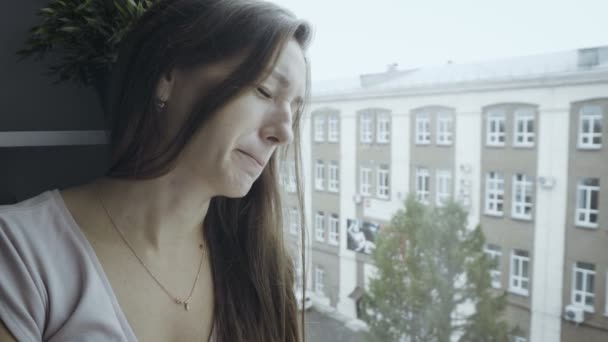 Mujer triste apoyada en la ventana — Vídeo de stock