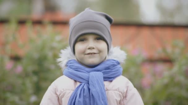 Маленькая очаровательная девочка позирует перед камерой — стоковое видео
