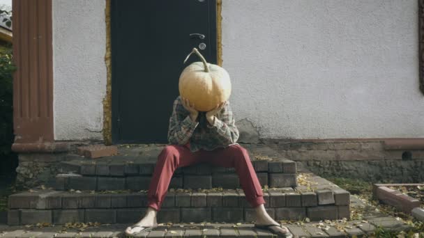 Sconvolto zucca-testa femminile seduta sul portico di una vecchia casa — Video Stock