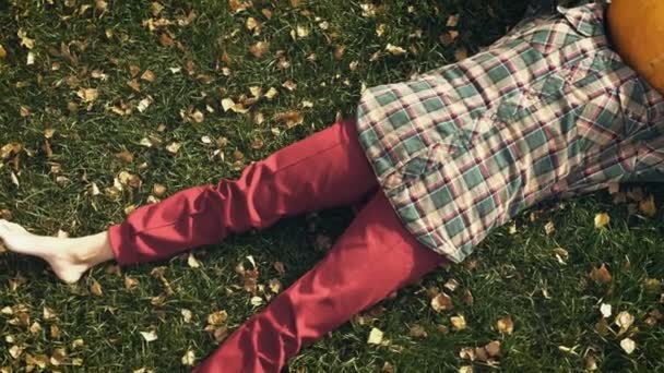芝生の上に横たわるパンプキン ヘッド — ストック動画