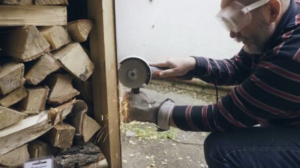 Man is het zagen van metalen constructie met een cirkelzaag — Stockvideo