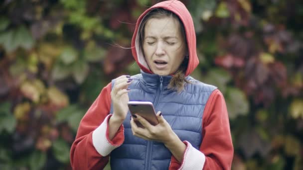 Junge Frau benutzt ihr Handy und niest — Stockvideo