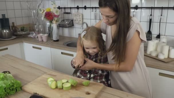 Μαμά και κόρη μαγείρεμα των λαχανικών στην κουζίνα — Αρχείο Βίντεο