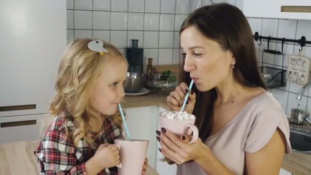 Mother and daughter drink cocoa with marshmallow — Stock Video