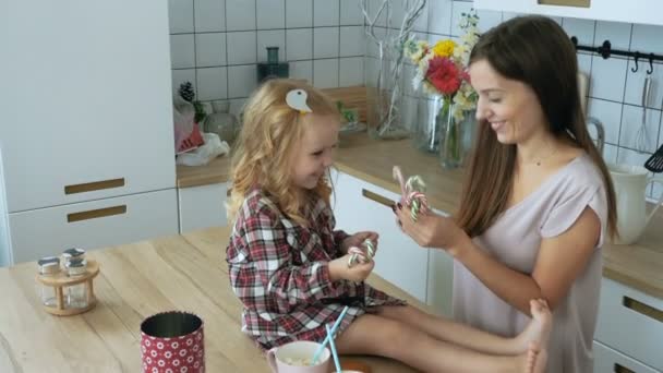 Vrouw met meisje speelt met Kerstmis riet van het suikergoed — Stockvideo