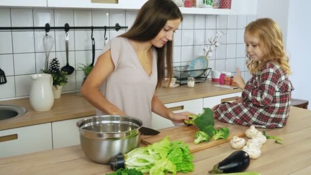 Mom and daughter cooking vegetables at the kitchen — Stock Video