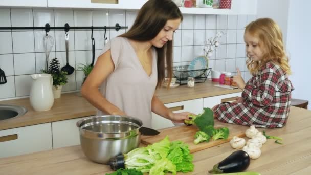 Mamá e hija cocinando verduras en la cocina — Vídeo de stock