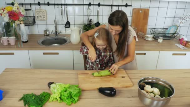 Mamá e hija cocinando verduras en la cocina — Vídeo de stock