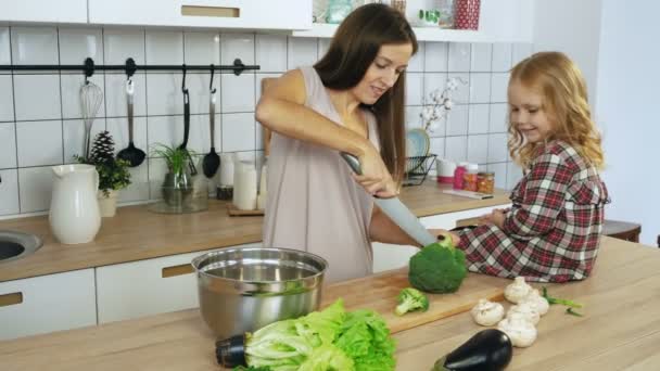 Mamá e hija cocinando verduras en la cocina — Vídeos de Stock