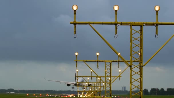 Avión aterrizando en pista iluminada — Vídeo de stock