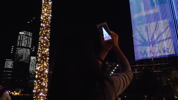 Menina está filmando a torre Burj Khalifa à noite — Vídeo de Stock