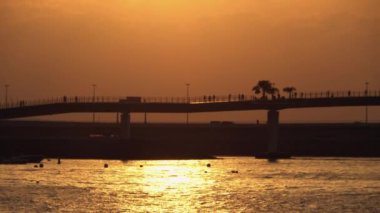 Gün batımında sahilde kalabalık siluetleri