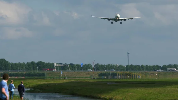Les gens regardent l'avion approcher de l'aéroport — Photo