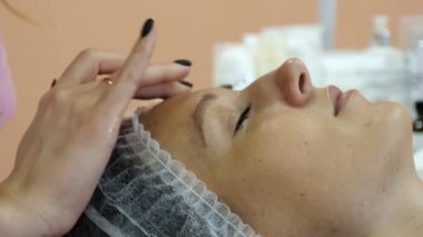 Güzellik uzmanı istemcileri yüz kremi ile smear