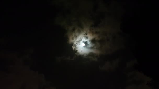 Nuages passant par la lune la nuit .