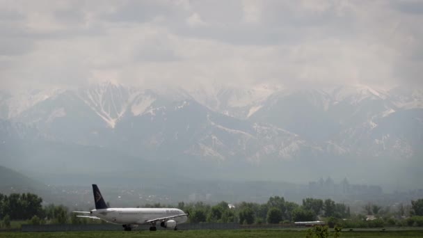 Jetairliner of Air Astana taxiing against mountains — Stock Video