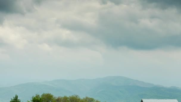 Time lapse rurale con cabine rustiche contro le montagne — Video Stock