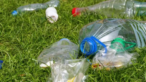 Plastic flessen liggen op het gras. — Stockvideo