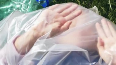 Plastik kirliliğinin kavramsal görüntüleri. Plastik torbanın içinde yatan kadın.