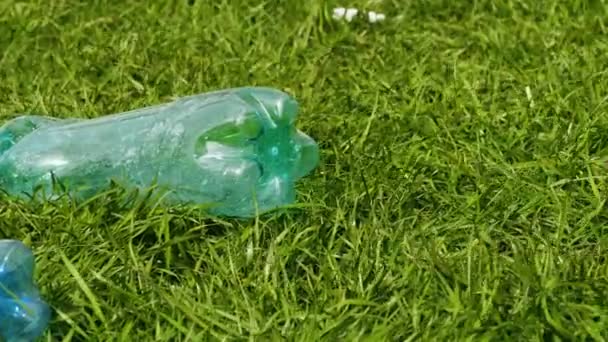 Garrafas de plástico poluem o gramado — Vídeo de Stock