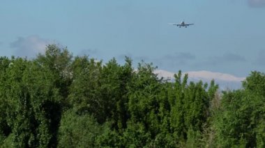 Ticari uçak arka planda güzel dağlar ile yaklaşıyor