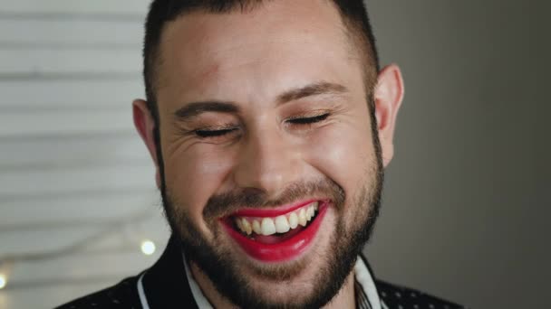 Beau jeune homme avec un maquillage lumineux riant de la caméra — Video