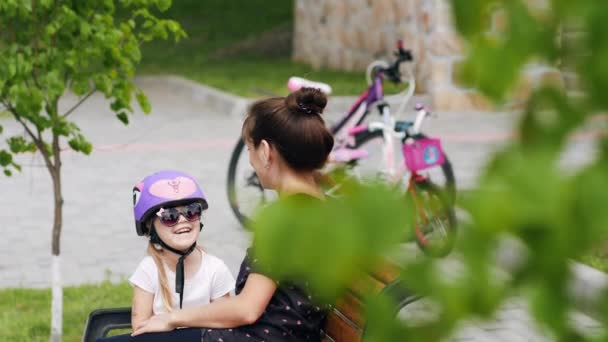 Žena a malá holčička odpočívá po jízdě na kole — Stock video
