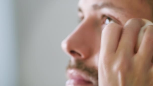 Artista de maquillaje hace maquillaje en la cara del hombre barbudo — Vídeo de stock