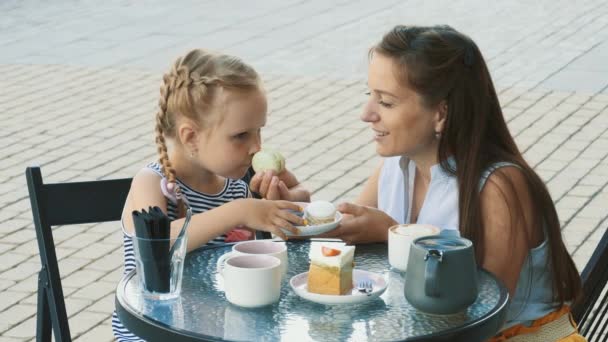 Η μητέρα και η χαριτωμένη μικρή κόρη της σε υπαίθριο καφέ — Αρχείο Βίντεο