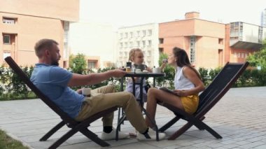 Mutlu genç aile birlikte sabah kahve içme kahvaltı yeme konuşuyor