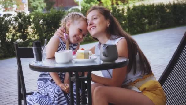 Mujer y niña se abraza en la cafetería — Vídeo de stock