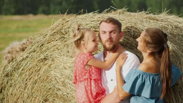 Familia feliz en el prado posando contra pajar — Vídeo de stock