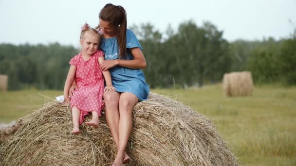 Mutter mit Tochter sitzt auf Heuhaufen — Stockvideo