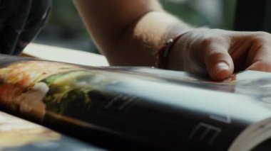 Menü sayfalarını araştıran kadın