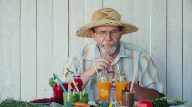 Yaşlı adam çeşitli smoothies tadı