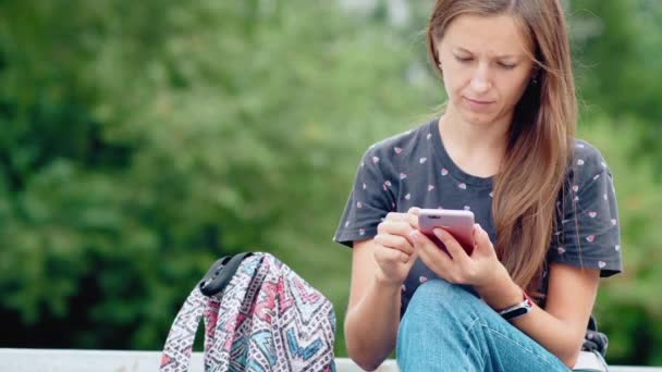 Junge Frau benutzt ihr Handy — Stockvideo