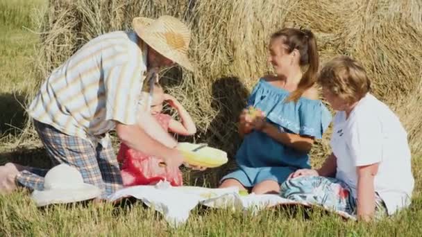 Щаслива сім'я на пікніку на лузі — стокове відео