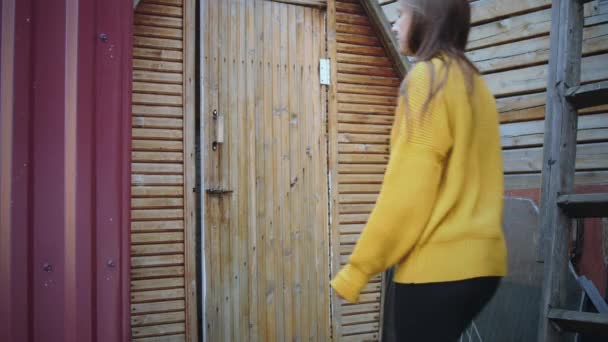 Mujer entra al baño exterior en un pueblo — Vídeo de stock