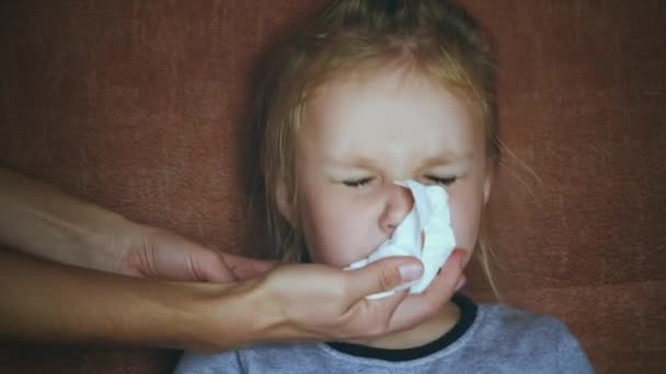 A mother helps her sick little daughter blow her nose — Stock Video