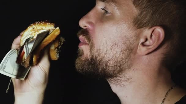 Homme mangeant hamburger avec des dollars américains — Video
